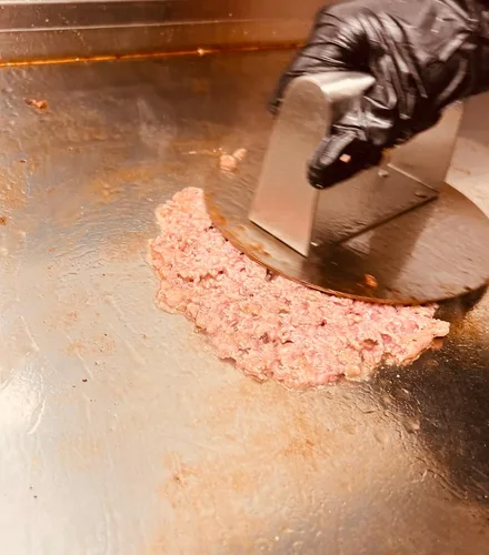 Das Fleisch kommt als Kugel auf die Platte, bevor es flach gedrückt wird