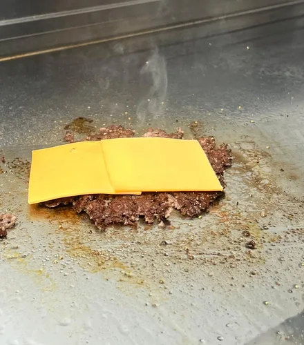 American cheese melting on a freshly smashed patty